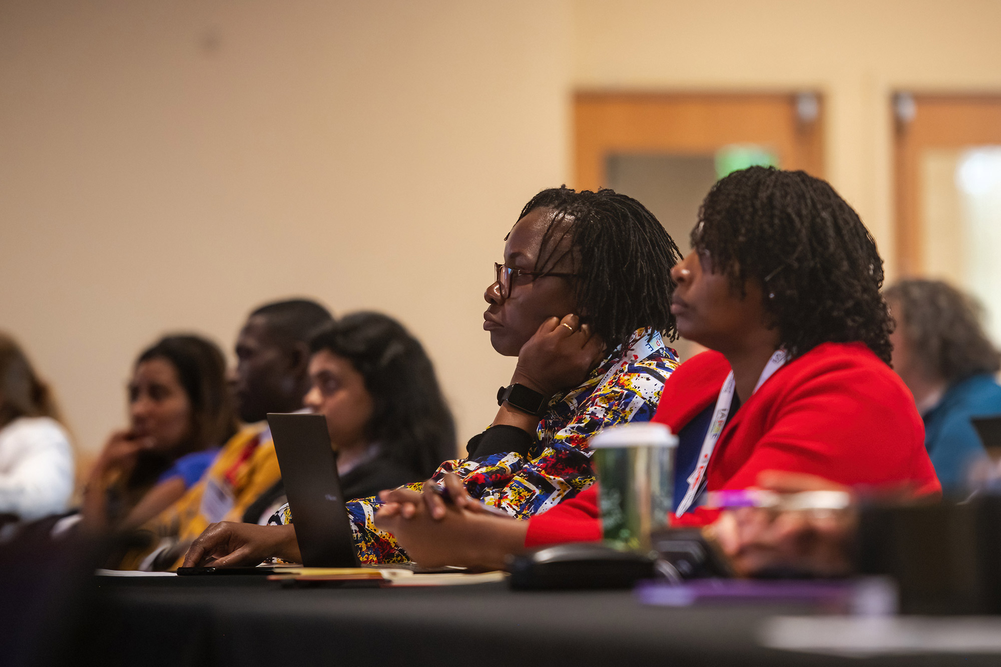 Conference attendees listen and take notes during a keynote talk.