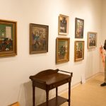 Steve Riffee hangs Queena Stovall paintings in the Daura Gallery.