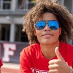 Student wearing sunglasses and giving a thumbs up.