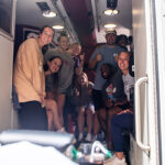 A group of MSAT students gathered in the back of an ambulance.