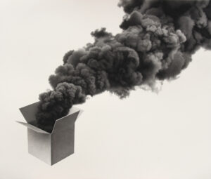 A gray box on a white background with black smoke coming out